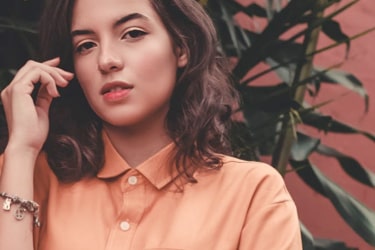 woman in an orange shirt looking at the viewer